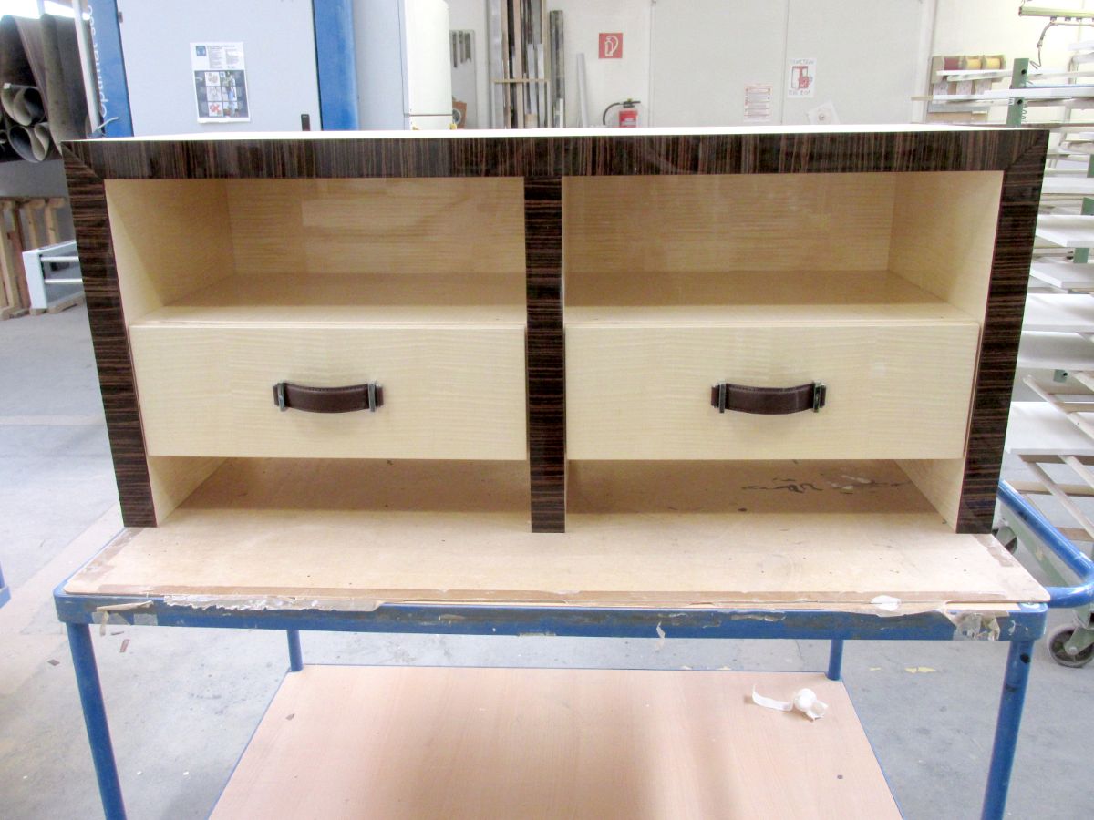Dunkles Sideboard mit Hochglanzfurnier im Yachtinterieur